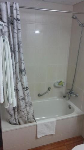 埃斯波特Hostal Casa Palmira的带浴缸和淋浴帘的浴室
