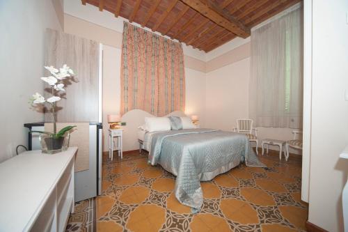 卢卡Lucca Relais的卧室配有一张床和一张桌子及椅子