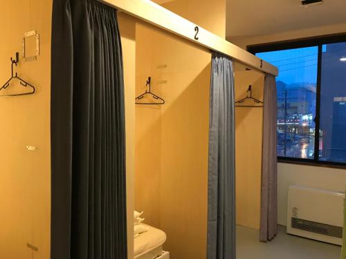 钏路Guest House Proof Point的带淋浴和卫生间的浴室以及窗户。