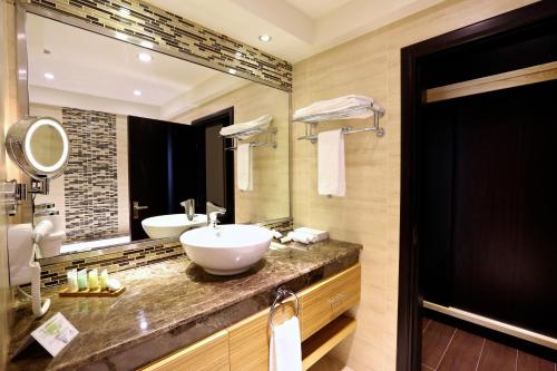 阿布扎比Nehal Hotel的一间带两个盥洗盆和大镜子的浴室