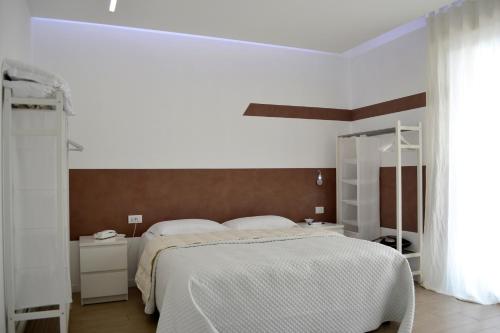 滨海波利尼亚诺B&B Dimora Silvestri的白色卧室设有一张大床和镜子