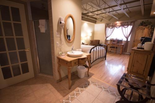 Amos德斯艾斯科尔斯酒店的一间带水槽、床和镜子的浴室