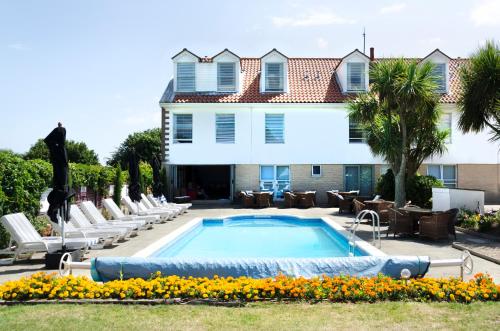 圣赫利尔泽西海浪酒店的一座带躺椅的房屋前的游泳池