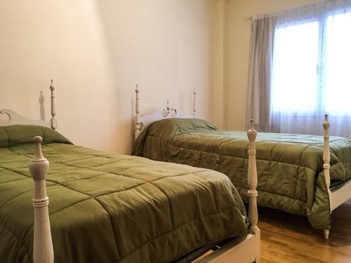 布兰卡港Departamento Temporario Bahia Blanca的卧室设有两张单人床和窗户。