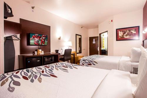 特拉弗斯城Seasons Inn Traverse City的酒店客房配有两张床和一张书桌