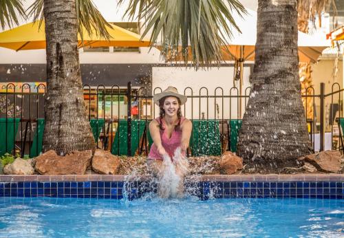 艾利斯斯普林斯YHA Alice Springs的坐在游泳池的水中的女人