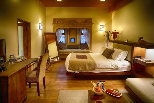 斋沙默尔第一门融合酒店的一间卧室配有一张床和一张书桌
