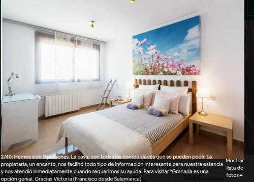 阿尔米利亚Casa Escapada a Granada的卧室配有一张床,墙上挂有绘画作品