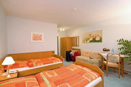 文斯托夫布鲁姆威曼妮酒店的一间卧室配有两张床、一张沙发和一张桌子