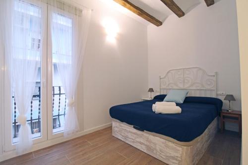 安波拉Bonito Loft en L'Ampolla的一间卧室设有蓝色的床和窗户。