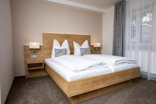 上阿斯巴赫Gästehaus - Kretschmannshof的卧室配有一张带白色床单和枕头的大床。