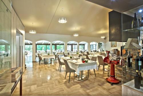 卢恰纳瓦尔特家庭酒店的餐厅设有白色的桌椅和窗户。