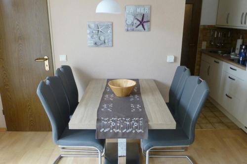 万根沃格Villa Marina Wangerooge的一张带蓝色椅子的餐桌和碗