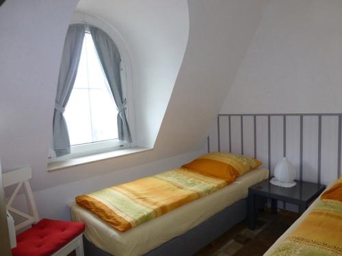 万根沃格Villa Marina Wangerooge的一间小卧室,配有床和窗户
