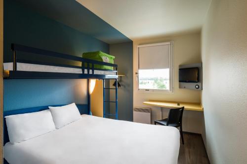 蒙泰夫兰马恩河谷欧洲谷宜必思快捷酒店 的一间卧室配有一张床、一张书桌和双层床。