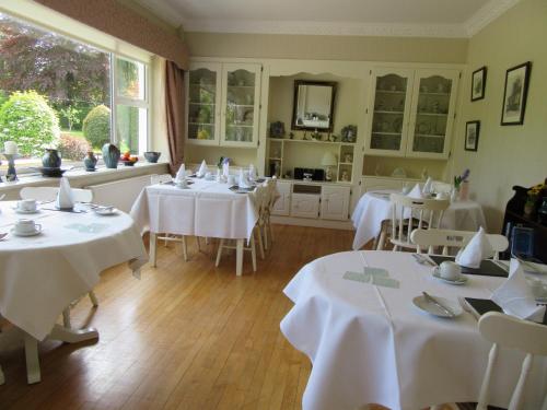 卡舍尔copperfield house的用餐室配有白色的桌子和白色的椅子