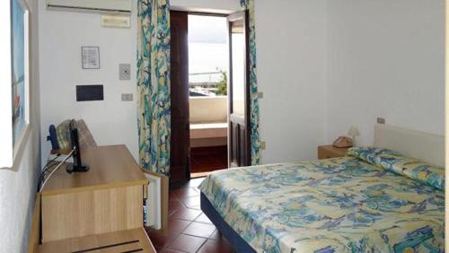 圣马里纳萨利纳Hotel Bellavista的一间卧室配有一张床和一张书桌及电话