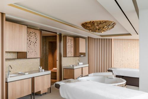 ChampillonRoyal Champagne Hotel & Spa的一间带两张床、浴缸和水槽的浴室