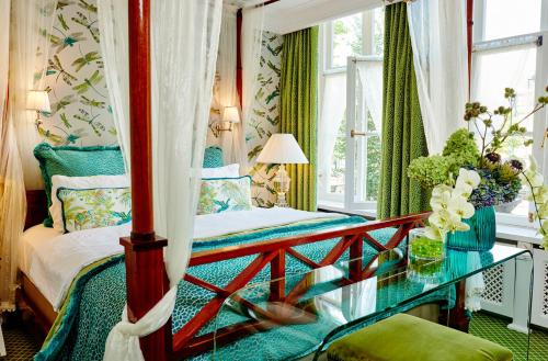 阿姆斯特丹艾斯特雷酒店的一间卧室配有一张床和一张玻璃桌