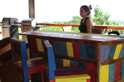 Los DuarteHotel El Sol Morrillo的坐在酒吧里,有一张五彩缤纷的桌子的女人