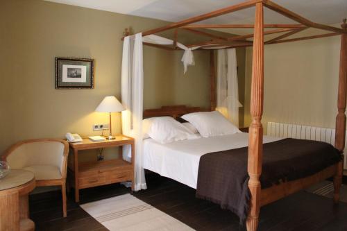昆卡昆卡酒店的一间卧室配有一张天蓬床和一张带台灯的桌子