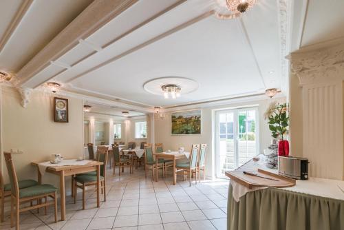 德累斯顿瓦德斯罗斯琛别墅酒店的一间在房间内配有桌椅的餐厅