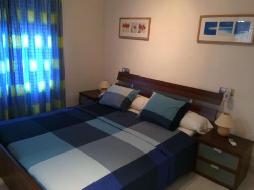 拉尔法斯德尔皮Casas Blancas Bungalow 45的卧室配有蓝色和白色的床和窗户。