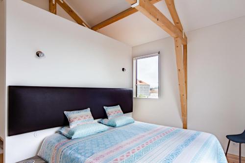 波尔图Amazing Penthouse Apartment in historic Porto的一间卧室配有一张大床和黑色床头板