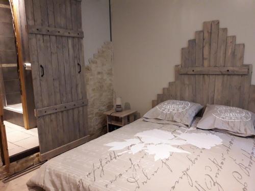 萨尔拉拉卡内达Les farios的一间卧室配有一张带木制床头板的床