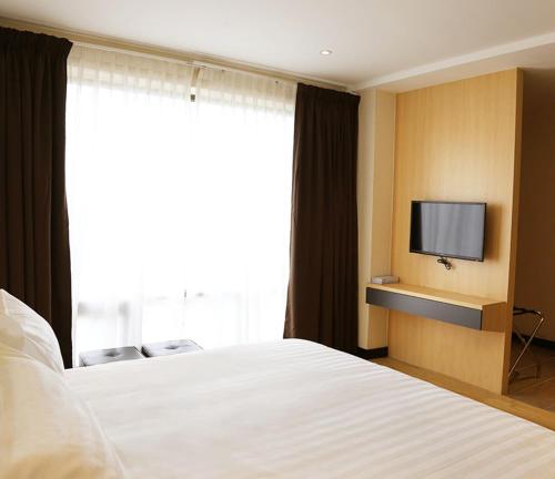 安顺Rivertel的一间酒店客房,配有一张床和一台电视