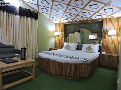 西姆拉Hotel Chaman Palace的一间卧室配有一张床、一张沙发和一张桌子