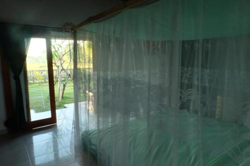 普卢坎THE NYAMO surf & stay的一间卧室配有一张带窗帘的床和窗户