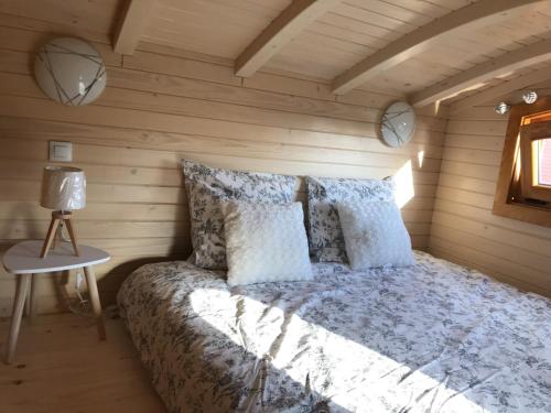 FaycellesTINY HOUSE & SPA的木制客房内的一间卧室,配有一张床
