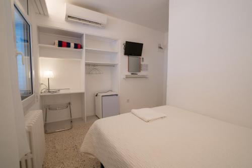 卡达克斯卡达克斯滨海旅馆的白色卧室配有床和书桌