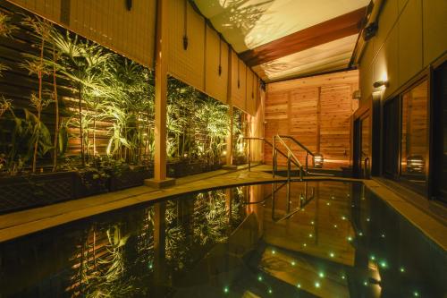 京都Capsule Hotel Anshin Oyado Premium Resort Kyoto Shijo Karasuma的一座植物壁画建筑中的游泳池