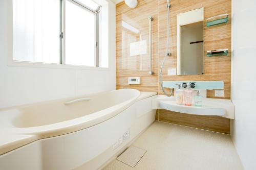 泉佐野JIYUKA INN的白色的浴室设有水槽和镜子
