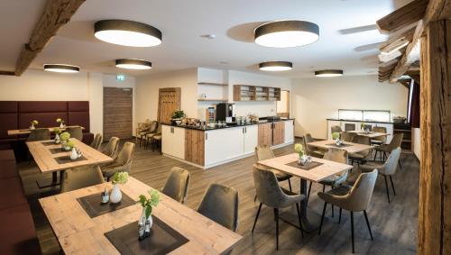 OberbechingenLandhotel Zum Adler的一间带木桌椅的餐厅和一间厨房