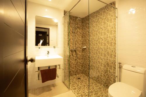 巴色Intouch Riverside Hotel的带淋浴、卫生间和盥洗盆的浴室