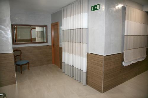 波索阿尔孔Hostal Restaurante Grela的走廊上设有椅子和窗户的房间