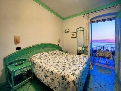 伊斯基亚Hotel Casa del Sole的一间卧室配有一张床,享有海景