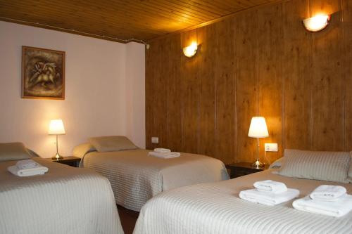 索尔德乌佩里托尔酒店的带3张白色床单的床的房间