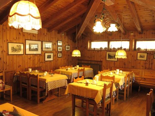 科涅Hotel Locanda Grauson的用餐室配有桌椅和吊灯。