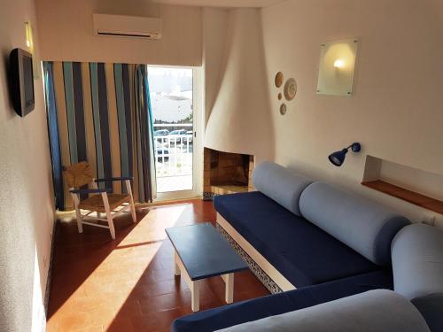 阿尔布费拉索尔多罗旅游公寓酒店的客厅设有蓝色的沙发和窗户。
