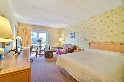 三河城Hotel Motel Penn-Mass的一间卧室配有一张床和一张书桌及电视