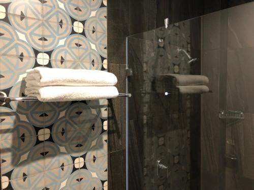 阿特利斯科Casa de la Audiencia的浴室配有淋浴和带镜子的毛巾架