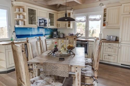 奥茨塞巴德·迪尔哈根Penthouse Meerblick的厨房配有木桌和一些椅子