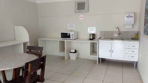 瓜拉图巴Hotel Santa Paula的厨房配有桌子、水槽和微波炉
