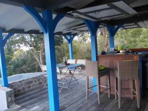 下岛Les Hauts de la Baie的一个带蓝色柱子和桌椅的甲板