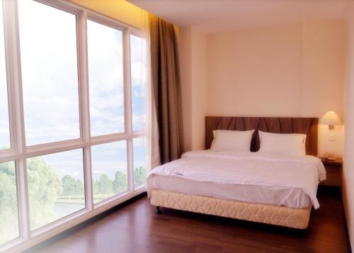 科塔达曼萨拉贝塔陵嘉耶9号广场酒店 的一间卧室设有一张床和大窗户
