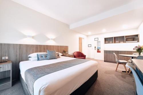 拉弗顿拉弗顿俱乐部酒店的酒店客房设有一张大床和一张桌子。